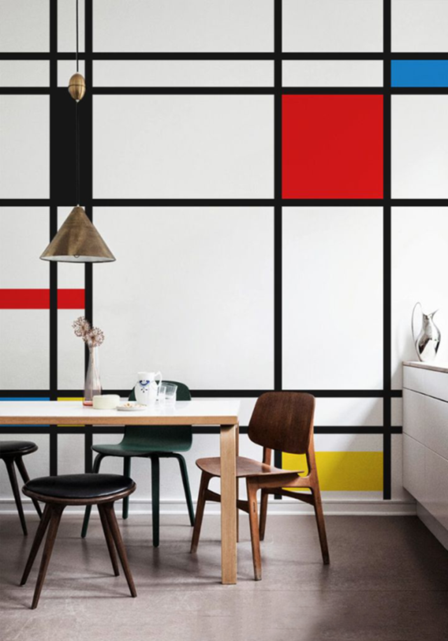 Se não prestássemos atenção aos detalhes, este ambiente seria apenas mais uma sala de jantar “moderninha”. A parede inspirada na obra de Mondriam, projetada pelo estúdio PIXERS, confere elegância e minimalismo à decoração. Uma mistura de senso artístico com inteligência.