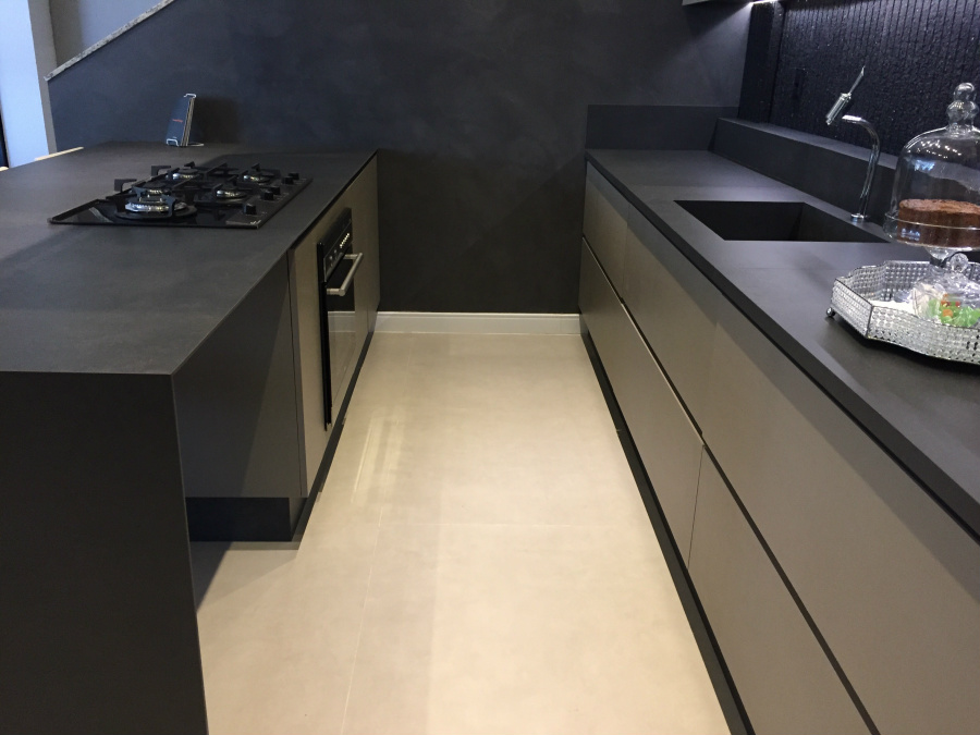Bancada e pia da cozinha revestidas com porcelanato referenciando cimento queimado